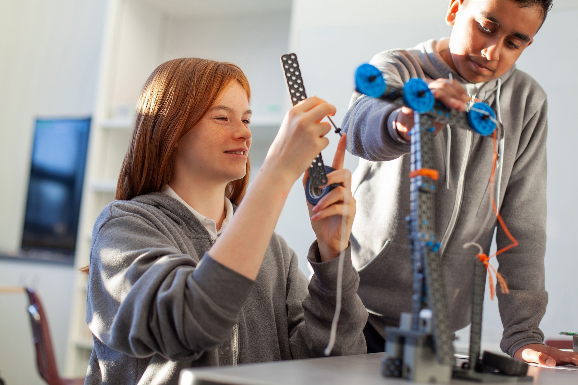 Adolescente en el aula de la escuela secundaria haciendo física, construcción, ciencia, ingeniería, tecnología, matemáticas, proyecto STEM con un compañero de clase asiático